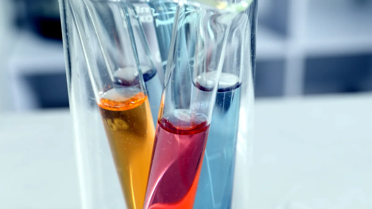 Tubos de ensayo con muestras biologicas ordenados en un portatubos sobre una mesa de laboratorio.