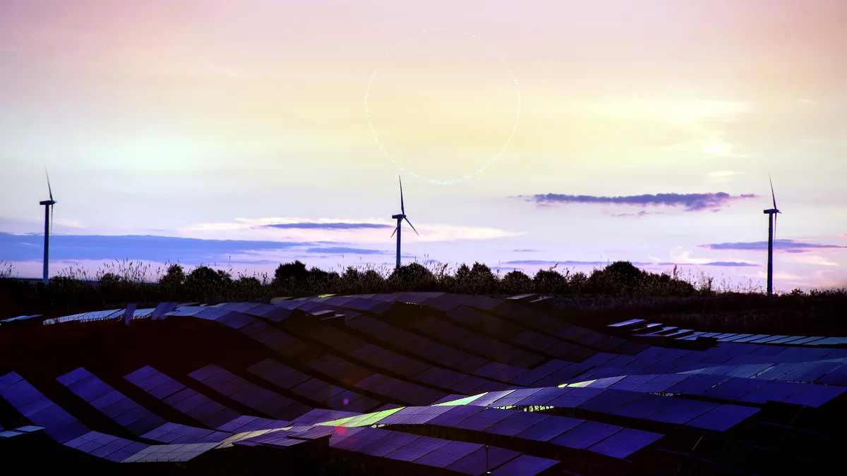 Un campo extenso de paneles solares reflejando la luz anaranjada del ocaso.
